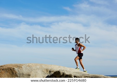 Fitness man running outdoors with high speed, sportsman on the morning jog runs over sea rocks