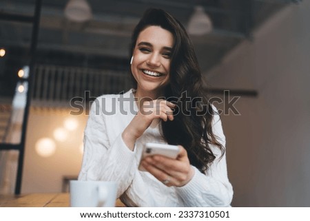 Similar – Image, Stock Photo Young dark haired woman with curls and freckles looks half behind white steam cloud into camera in blue green light