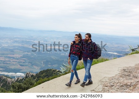 Happy young couple spending time together outdoors while out hiking in mountains