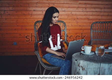 Attractive young woman working with computer browsing in cafe