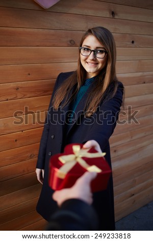 First person portrait of hand of man giving saint valentine\'s gift in to his smiling girlfriend