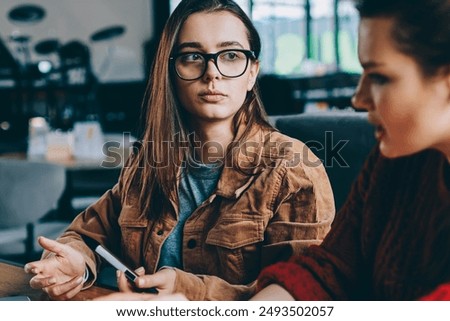 Foto Bild Zwei College-Mädchen studieren gemeinsam zu Hause mit Laptops beim Kaffeetrinken