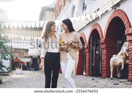 Similar – Image, Stock Photo Delighted female friends walking along street