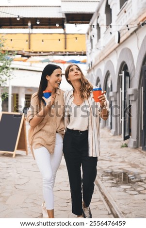 Similar – Image, Stock Photo Delighted female friends walking along street