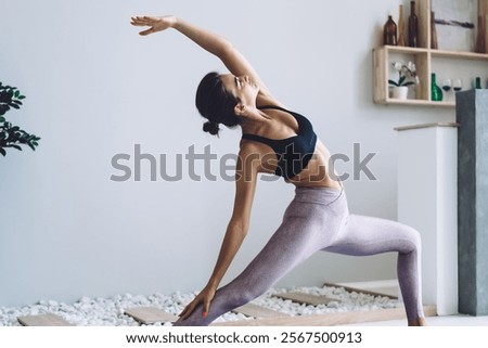 Image, Stock Photo Slim barefoot woman meditating in bound angle pose in contemporary workout room