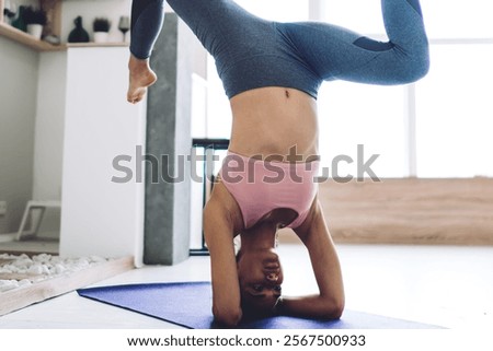 Image, Stock Photo Slender barefooted woman stretching body in bound angle pose in contemporary studio