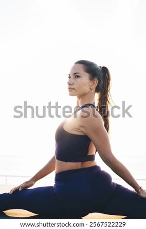 Similar – Image, Stock Photo Slender barefooted woman stretching body in bound angle pose in contemporary studio