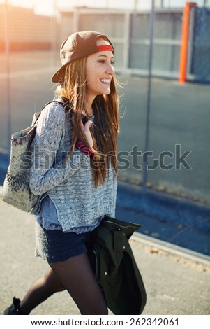 Cropped shot of a young stylish teenager walking in the street looking into the distance and feeling so happy,beautiful young female walk on a street relaxing and enjoying sunny evening outdoors,flare
