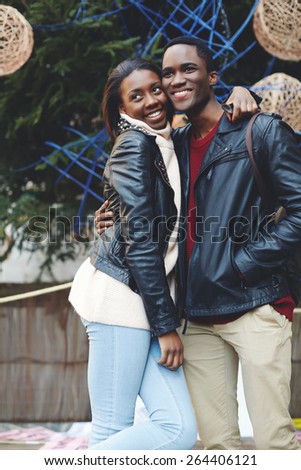 Laughing couple on christmas vacation walk in the city, beautiful young couple having fun during their vacation holidays, romantic couple standing on christmas tree background at big square