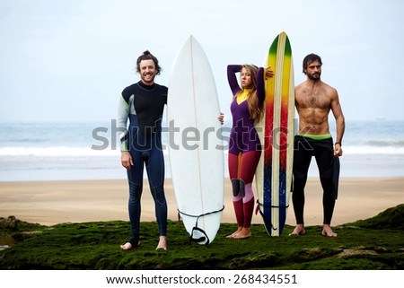 Happy friends with surfboards on tropical beach, summer lifestyle concept, group of friends having fun on seashore