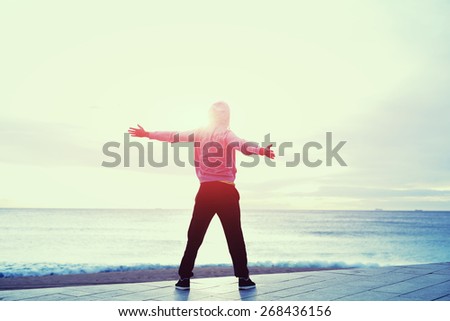 Full length portrait of sporty man with arms raised relax and enjoying the life feeling free and happy