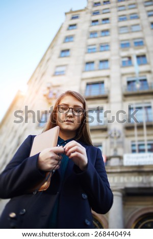 Portrait of elegant young woman standing in the urban setting looking pensive and upset