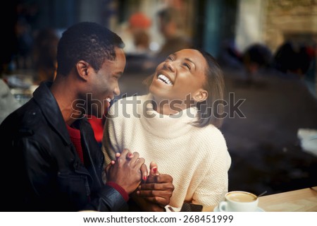 Two people in cafe enjoying the time spending with each other, happy stylish friends having coffee together, laughing young couple in cafe, having a great time together, view through cafe window