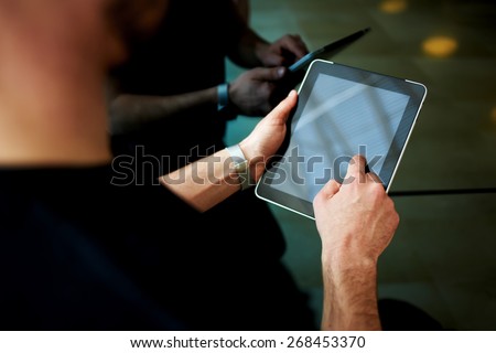 Rear view male person using digital tablet, business man or freelancer working on touch pad in elevator, businessman executive using wireless devices in modern office, young successful browsing on pad