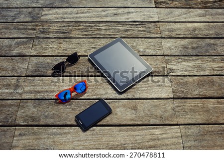 Top view mock up presentation with blank screen digital tablet, smart phone and couple of sunglasses lying on the wooden texture, vacation holidays or recreation time concept, objects on wooden pier