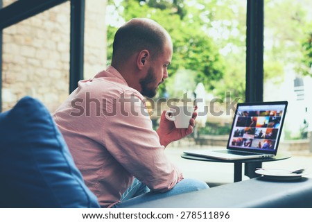 Modern business man connecting to wireless on his laptop computer during coffee break, male freelancer drink tea while working on notebook in loft studio, university student working at cafe or library