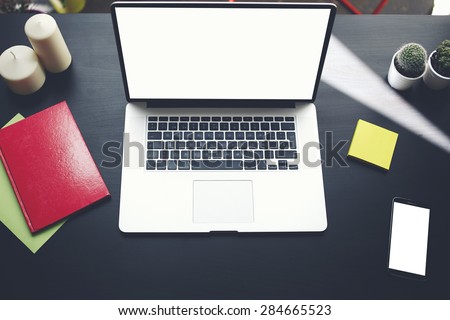 Top view of workplace with open laptop, notebook, empty screen smart phone and stickers lying on the table, computer with blank copy space screen for your information or content, distance work concept