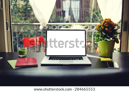 Freelancer needs workstation, workplace with laptop, smart phone, notebook and pot of flowers, open computer with blank copy space screen for information or content, on-line learning or distance work
