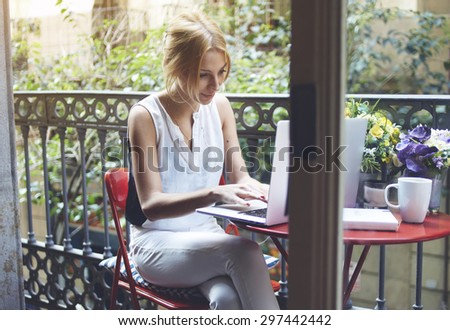 Gorgeous female student writes course work on her computer, freelancer girl working at home via net-book, young woman writes a text message on laptop keyboard while having recreation time at home