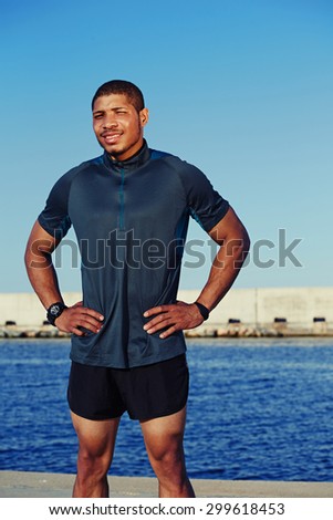 Strong muscular male jogger took break after workout standing against the sky  background with copy space area for your text message information, sweaty athlete resting after running in summer day