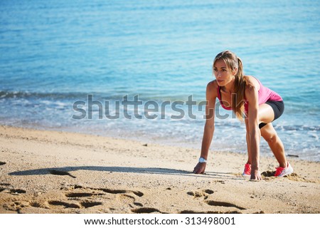 Full length portrait of gorgeous female runner with beautiful figure preparing for jogging on the beach while stretching legs muscles,  young fit woman doing an active exercise outdoors at seashore