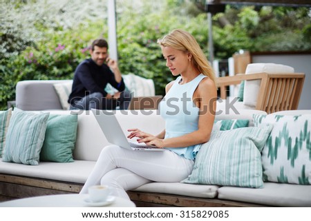 Young woman writes keyboarding text on laptop while sitting in cafe,successful businesswoman work on her computer during work break, women entrepreneur in elegant clothes use laptop in coffee shop