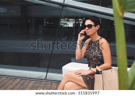 Portrait of a elegant businesswoman using smart phone in urban setting, female employed calling with smart phone while waiting for someone, elegant lady having mobile phone conversation outdoors