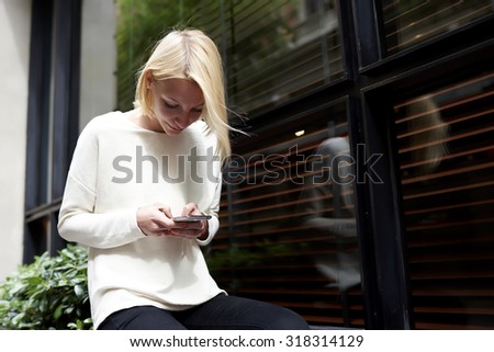 Trendy young woman focused chatting or talk on smart phone near blank copy space background for your content or text message, female hipster student using mobile phone for connect to wireless outdoors