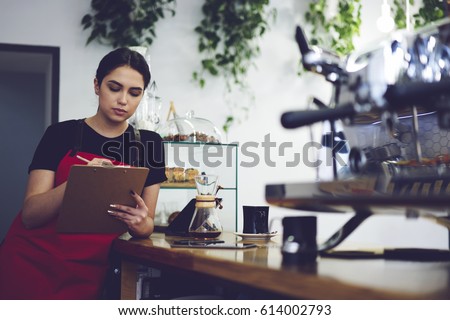 Image, Stock Photo Concentrated female cashier in face mask working with cash till