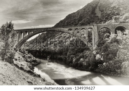 The second longest stone arch bridge in the world (Solkan, Slovenia). Built 1900 - 1905. HDR photo processed in vintage style with added grain.