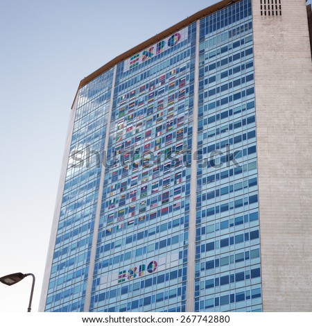 MILAN, ITALY-APRIL 8, 2015: EXPO 2015 logo and national flags on the Pirelli skyscraper in Milan. Expo Milano 2015 is the Universal Exhibition that Milan, will host from May 1 to October 31, 2015.