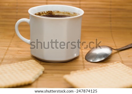 Cup of coffee and biscuit isolated on the bamboo mat