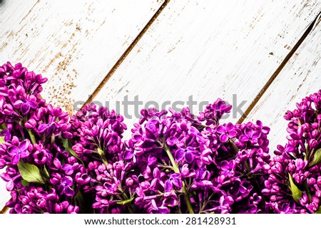 Lilac flowers on wooden planks background useful as greetings card, invitation cards, wedding invitation and postcards with place for text.