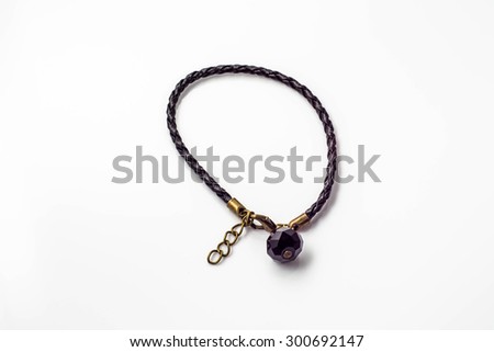 Close-up of handmade bracelet made with black leather and black crystal glass isolated on white background, fashionable simple made.