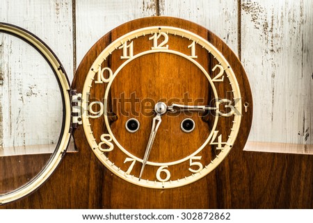 Old vintage clock on wooden wall background. Concept of the passage of time.