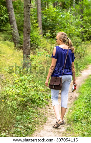 Young attractive woman walking through forest.