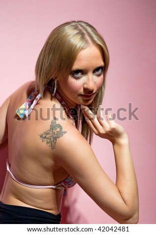 Blond girl with angel tattoo on her shoulder