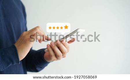 close up on customer man hand pressing on smartphone screen with gold five star rating feedback icon and press level excellent rank for giving best score point to review the service , business concept Сток-фото © 