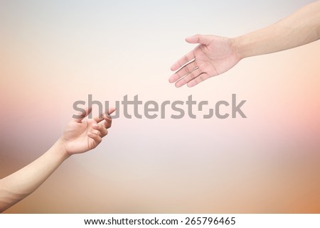 Human\'s hands help together on blurred twilight sky backgrounds.