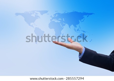Businessman\'s hand showing map of the world on blurred blue sky, selective focused.business concept