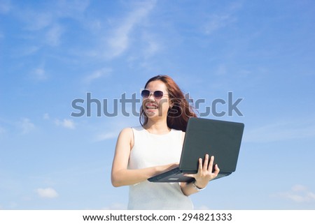 close up asian business woman working on laptop over blurred blue sky backgrounds : working woman love and happy to working.business concept.working concept.selective focused.