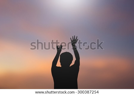 silhouette man praying over blurred twilight sky backgrounds.man pray to god for receiving power,strong and protect and blessing.religious concept.