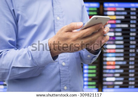 close up business man checking stock market by smart phone over blurred stock board.economics concept.business concept.