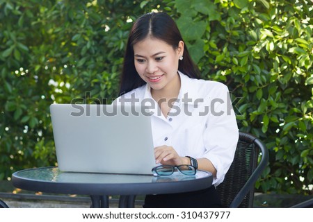 close up asian business woman working on laptop at outside office : working woman love and happy to working : working woman checking appointment .business concept.working concept.selective focused.