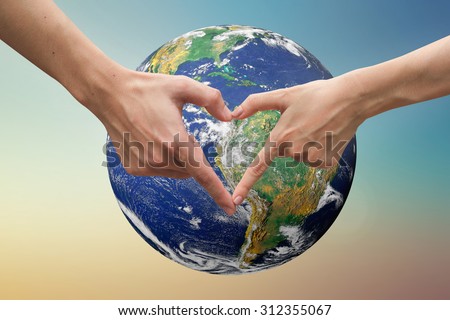 close up male and female hands making heart shape over the world.safe the world concept :symbols of human\'s hands to show that they love the world.Elements of this image furnished by NASA