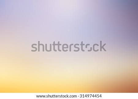 blurred twilight sky backgrounds with shiny flare light : blurred colorful purple,orange,yellow pattern with shiny light:blur backgrounds concept.
