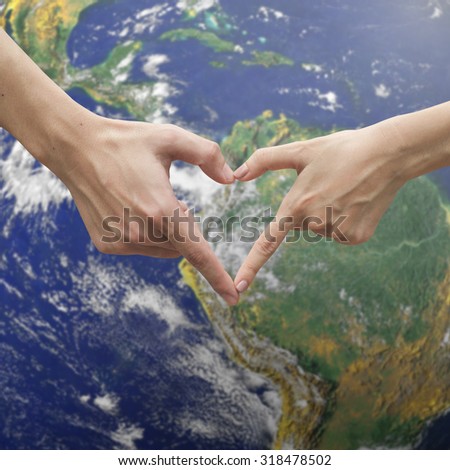 close up male and female hands making heart on blurred map of the world backgrounds. environment and ecology concept,soft focused.picture use for work about decorate,design,card,valentines and etc.
