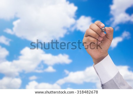 close up man hand writing over blurred blue sky and clouds background : teacher or business man\'s hand writing concept.education concept,business concept.