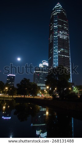 In the exhibition site: Trade Fair Tower, Messeturm, and full moon in Frankfurt, Germany