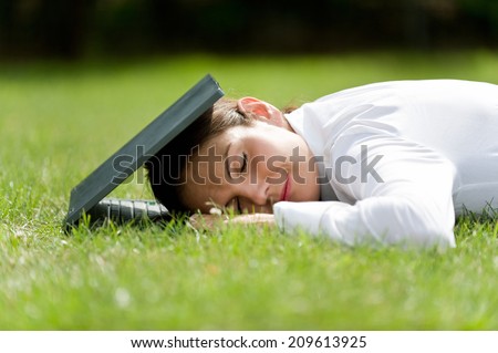 Rest after work, woman and computer, lying woman, lying woman with computer in the grass / Relaxation at work